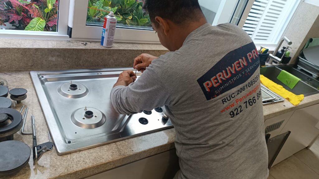 Técnico de Peruven Pro realizando mantenimiento de encimera a gas en cocina industrial