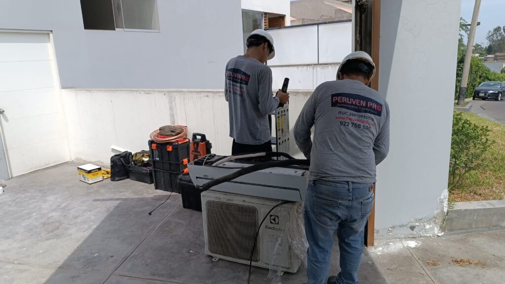 Técnicos de Peruven Pro reubicando unidad exterior de aire acondicionado en azotea